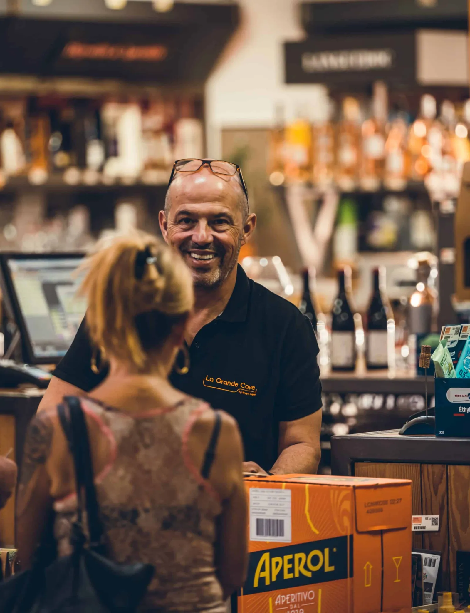 Caviste souriant devant ses bouteilles, brand content commerce South Management